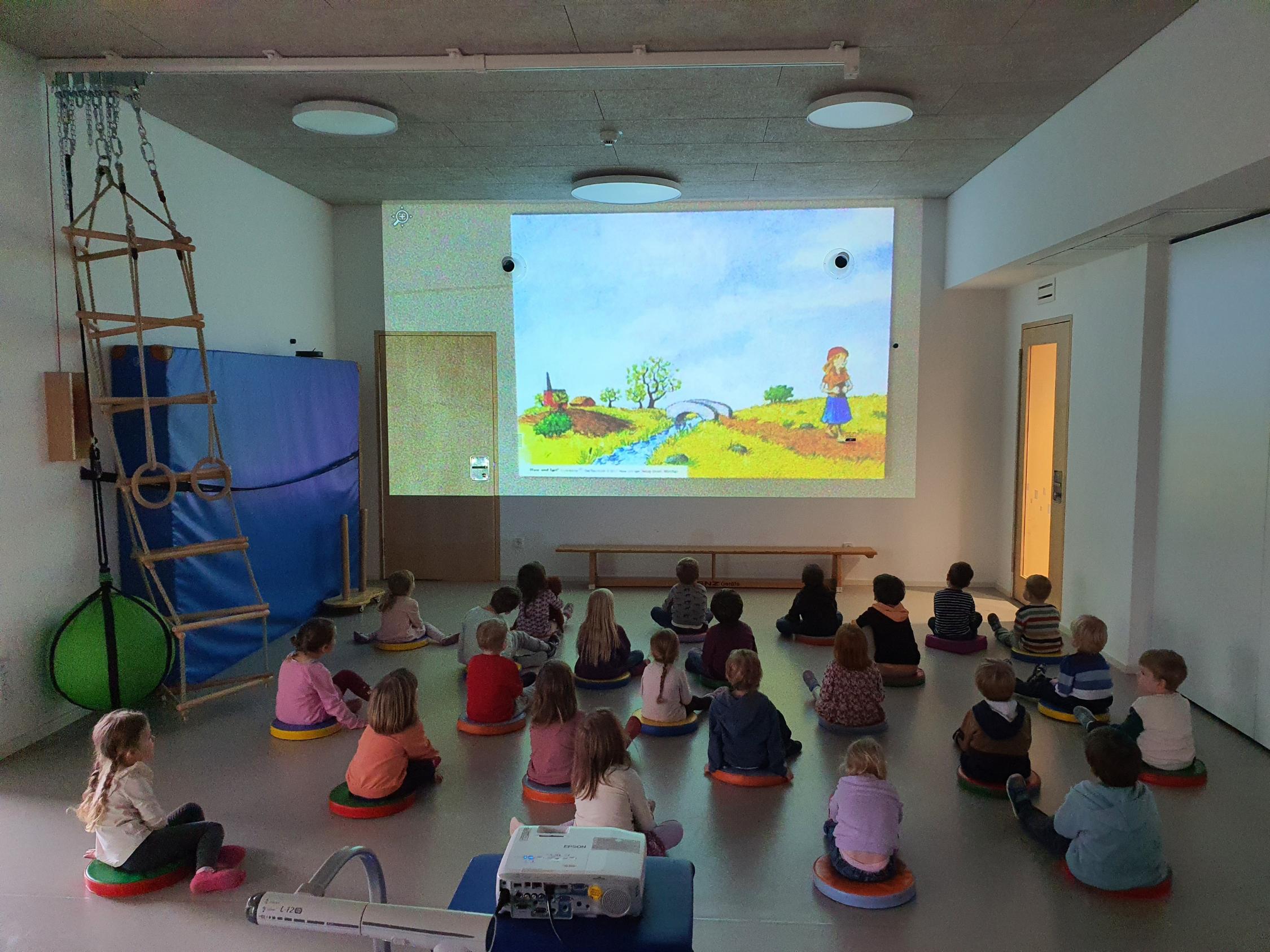 In der Turnhalle bekommen die übrigen Kinder ein Bilderbuch-Kino gezeigt
