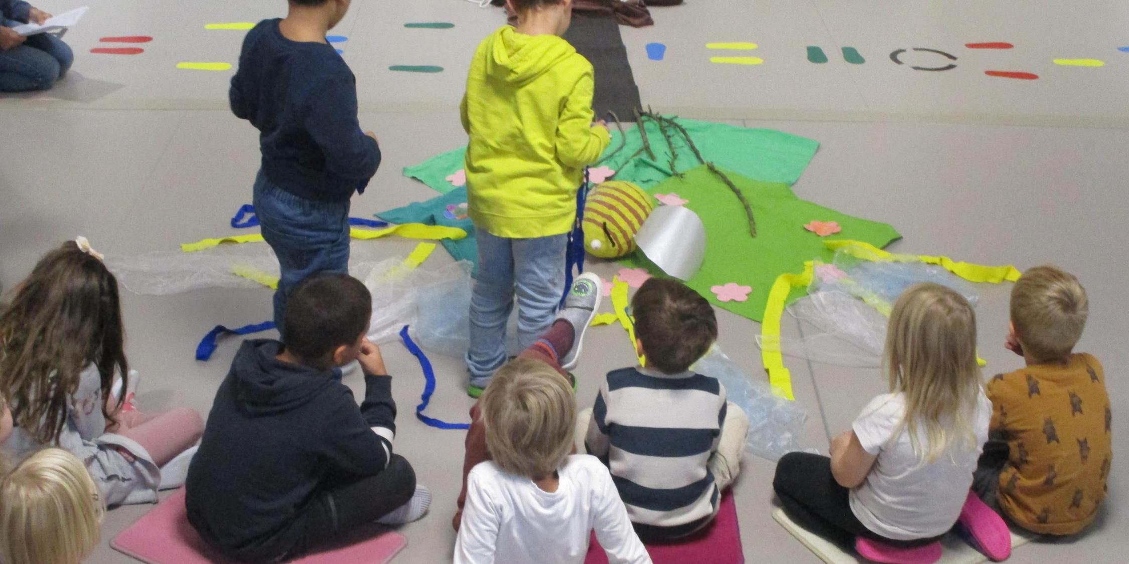 Vorschulkinder legen mit verschiedenen Materialien die Geschichte vom Apfelbaum